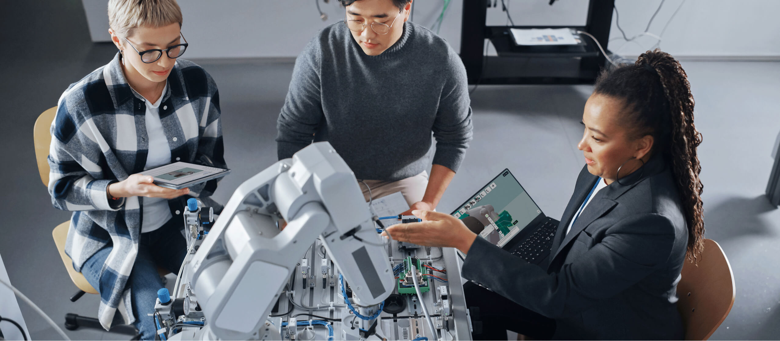 Three university engineering students collaborating on a robotics project in augmented reality with JigSpace software
